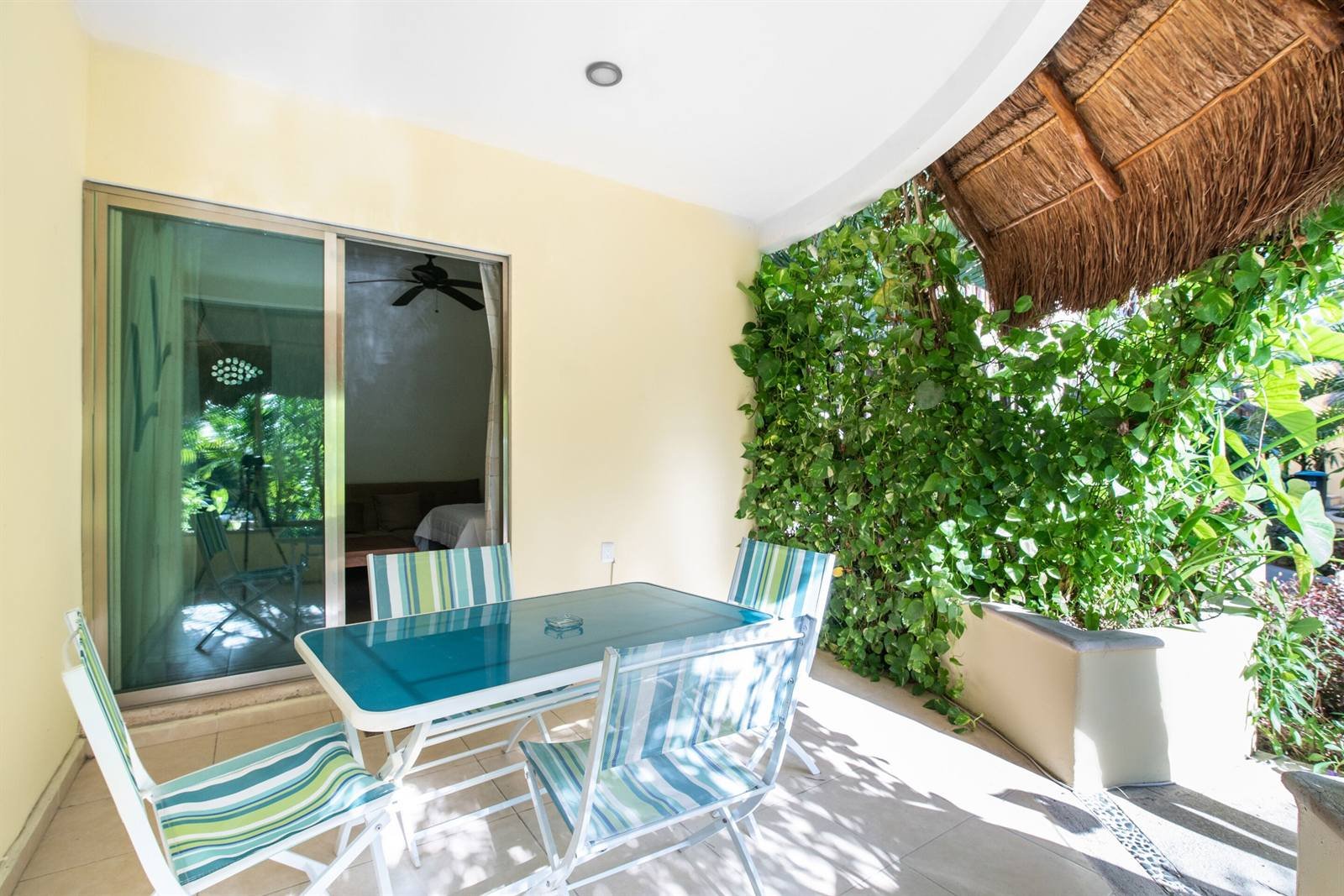 Villas Akalan: patio with outdoor table under a palapa and greenery